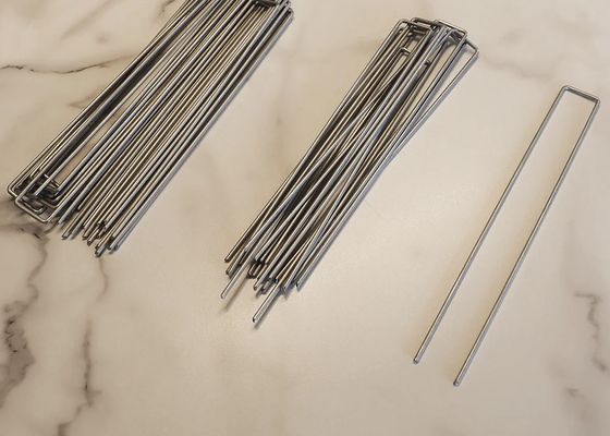 Stagli di legno da chiodo utilizzati come ancore per tessuti paesaggistici e pali da giardino